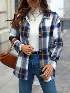 Close-up of flannel plaid shirt with dark buttons and orange stripes in urban setting