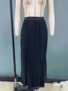 Close-up of black high-waisted pleated maxi skirt with elastic waistband on mannequin