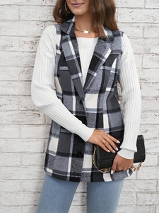 Detail view of black and white plaid sleeveless vest jacket with a gold chain handbag