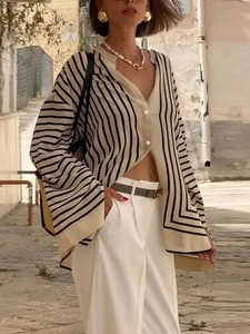 Detail of loose striped shirt with V-neckline and decorative geometric hem design