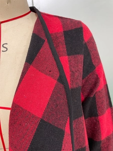 Détail du tissu à carreaux rouge et noir avec finitions de liseré sur le vêtement