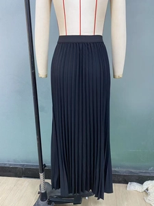 Close-up of black pleated maxi skirt with elastic high waist and fine fabric texture
