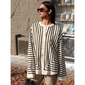 Detail of women's long-sleeve striped shirt showing buttons and woven texture in street setting
