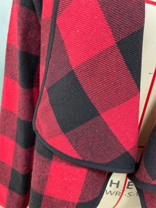 Détail du tissu à carreaux buffalo rouge et noir et du liseré de qualité sur le cardigan