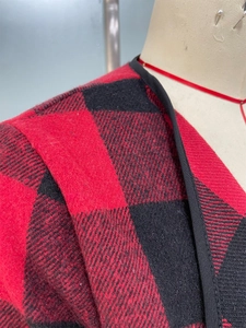Détail macro du tissu à carreaux rouge et noir avec bordure en textile noir fini