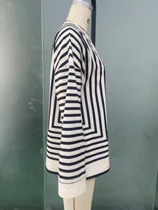 Detail view of geometric striped pattern and white cuffs on long-sleeved shirt