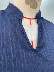 Detail of dark blue sleeveless dress featuring vertical textured fabric and V-neckline