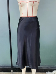Macro shot of elegant black satin midi skirt fabric with smooth glossy finish and drape