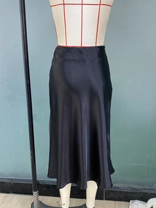 Detail view of the sleek black satin fabric showing elegant drape and smooth texture