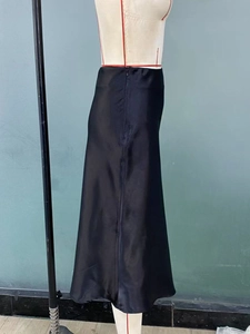 Detail view of the black satin midi skirt featuring a side concealed zipper closure