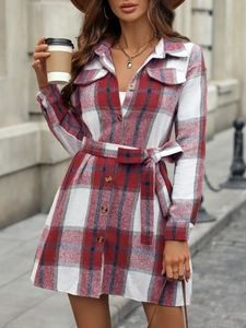 Detailed view of red plaid shirt dress featuring front pockets and a waist belt