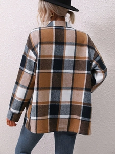 Rear view of brown and black plaid wool coat with long sleeves on a model against a white wall