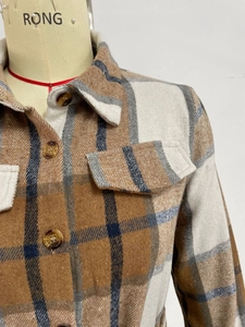 Detail of plaid long sleeve dress showing textured fabric with amber buttons and collar