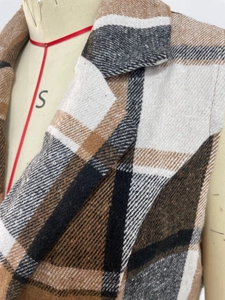 Gros plan détaillé sur le tissu à carreaux marron et la texture tissée du gilet à revers