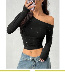 Close-up of black off-shoulder knit top with silver glitter and ribbed texture detail