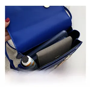 Internal view of the blue crossbody bag showing capacity for phone and wallet with chain
