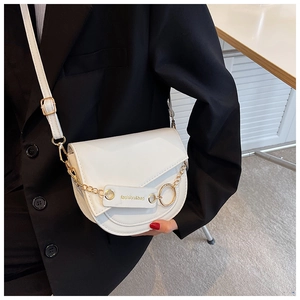 Detail view of the white saddle bag with golden chain and fashion engraving on leather