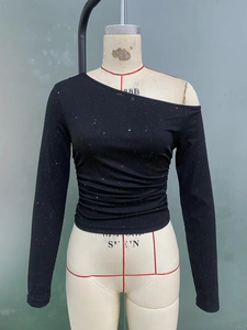 Close-up of black ribbed knit fabric with sparkling silver sequins and side ruching detail