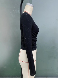 Close-up of black slim fit ribbed knit top featuring sparkling rhinestone embellishments