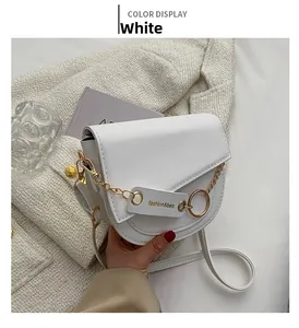 Detail of white leather crossbody bag with chunky gold chain and fashion tag