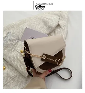 Detail of saddle bag with beige and brown PU leather panels and gold chain strap