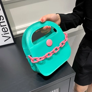 Détail du sac cabas vert menthe avec chaîne rose néon et boucle ronde