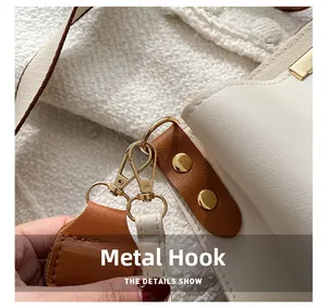 Gros plan du crochet doré et des garnitures en cuir marron sur un sac à bandoulière crème