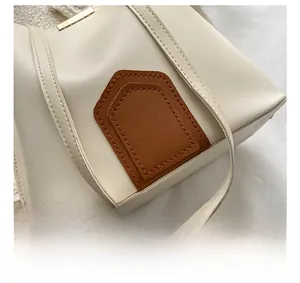 Détails du sac seau contrasté montrant des coutures précises et des ferrures dorées