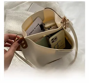 Vue de dessus montrant la grande capacité du sac seau beige avec des objets du quotidien