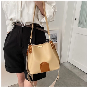 Détail du sac seau bicolore beige et marron avec deux bandoulières élégantes et amovibles