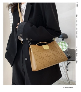 Detail of geometric embossed texture on brown bucket bag with silver hardware accents