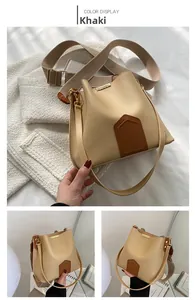Gros plan sur le sac seau kaki avec garniture en cuir brun et détails en métal doré