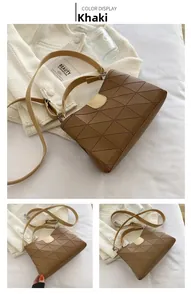 Detail of khaki bucket bag showing triangular geometric stitching and contrast lock closure