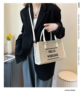 Detail of canvas tote bag with HELLO WEEKEND print and white leather handles