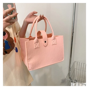 Close-up of pink felt tote bag featuring reinforced handle and minimalist stitching