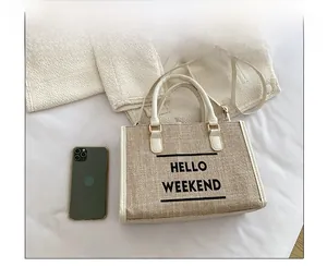 Detail of HELLO WEEKEND canvas tote bag with woven texture and synthetic leather trim