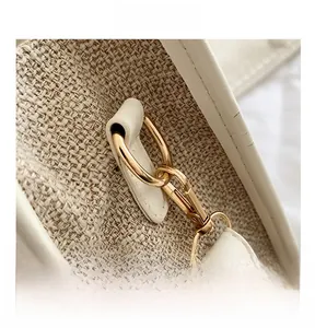 Detail showing high-quality golden metal hook and beige woven fabric with leather trim