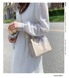 Style de rue extérieur d'un sac carré tissé beige avec nœud en dentelle blanche délicat