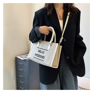 Detail of canvas tote bag with adjustable strap and HELLO WEEKEND text for summer style