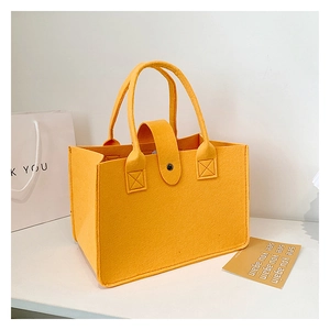Detail view of ginger yellow felt tote bag with handle and snap button closure