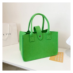 Detail view of vibrant green felt tote bag featuring reinforced stitching and snap closure