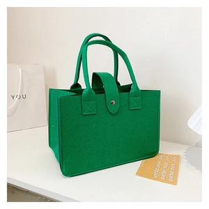 Detail of dark green felt tote bag featuring a secure flap closure and thick handles