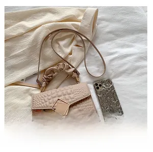 Détails du sac à bandoulière abricot avec texture crocodile et boucle dorée en métal