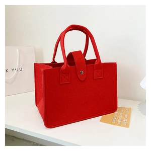 Detail of red felt tote bag showing thick fiber material and metal snap button closure