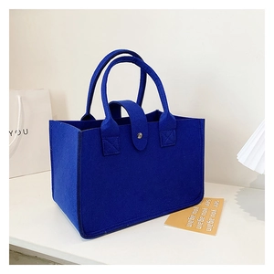 Detail of a navy blue felt tote bag with sturdy handles and a snap button closure