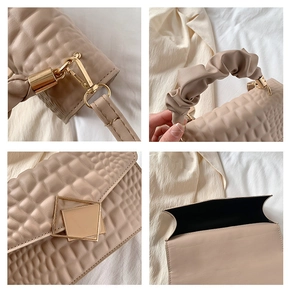 Détails du sac beige à texture crocodile avec boucles dorées et poignée froncée