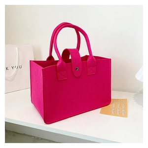 Detail view of rose red felt tote bag with sturdy handles and precise side stitching