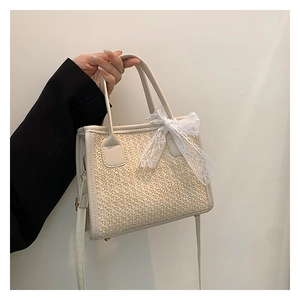 Détail du sac à main tissé crème avec nœud en dentelle délicat et texture en tweed