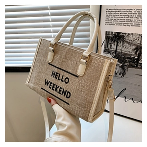 Detail of oat canvas tote bag with HELLO WEEKEND text and cream leather handles