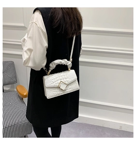 Rear view of a model wearing a white crocodile texture small crossbody bag with metal buckle